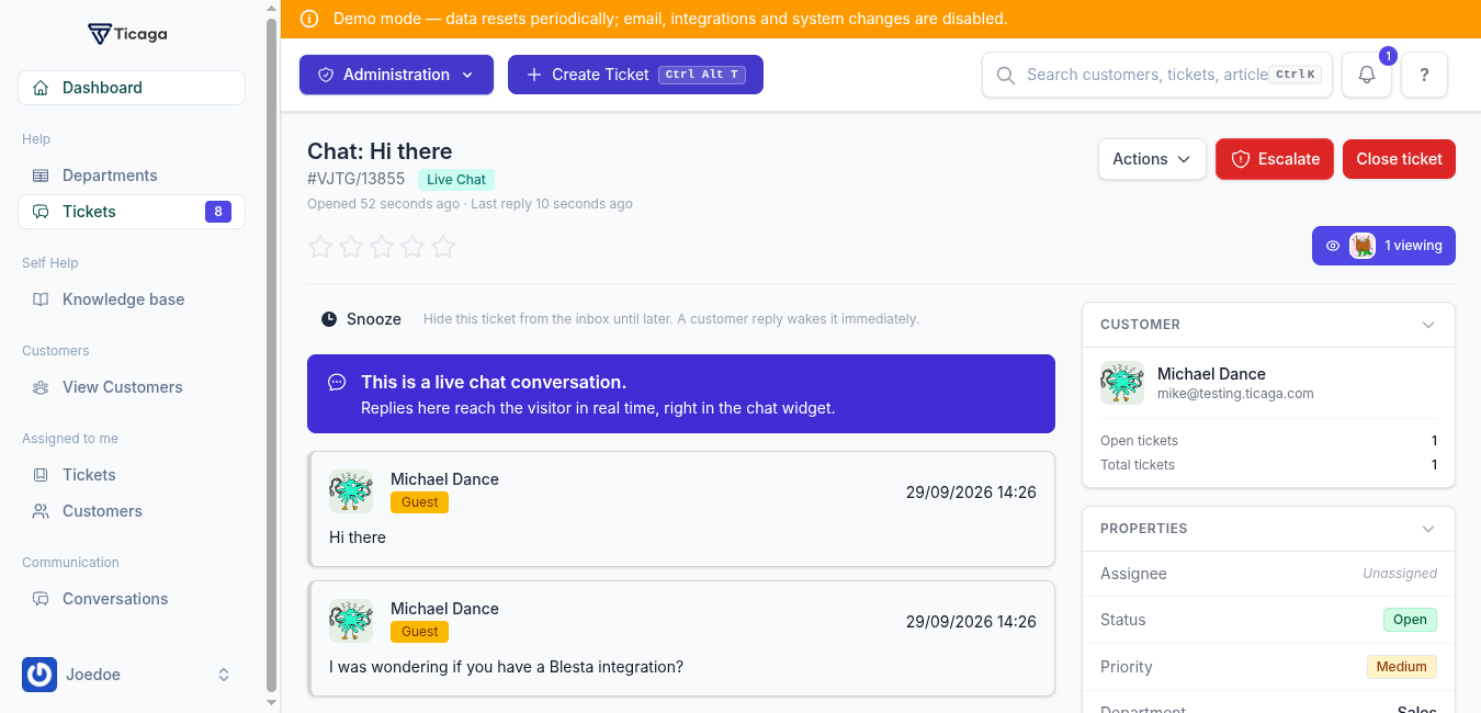 A live chat open as a ticket, with a banner explaining that replies reach the visitor in real time, the conversation, and the customer and ticket properties panels